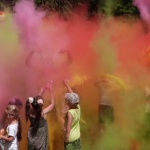 Festiwal kolorów. Dzieci rozrzucają kolorowe proszki w górę, unosi się kolorowa chmura.